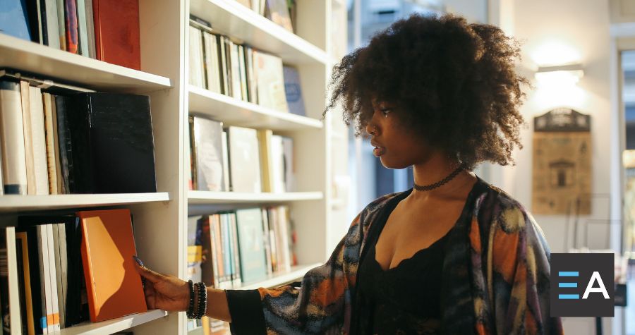 A person perusing a bookshelf