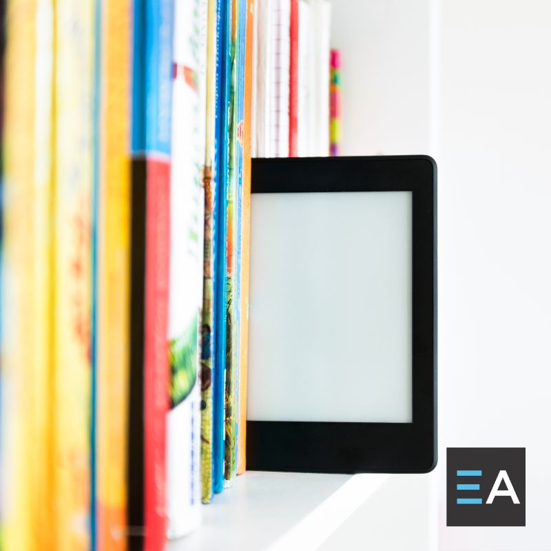 An e-reader on a shelf of books