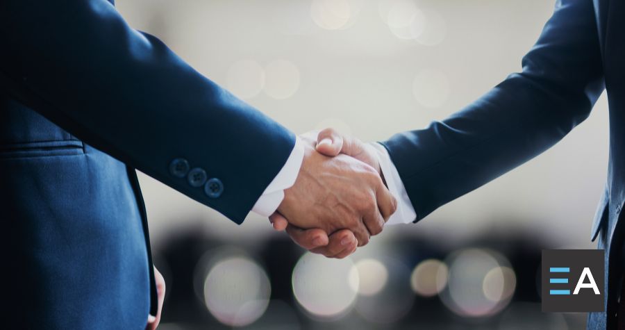 Two people in suits shaking hands