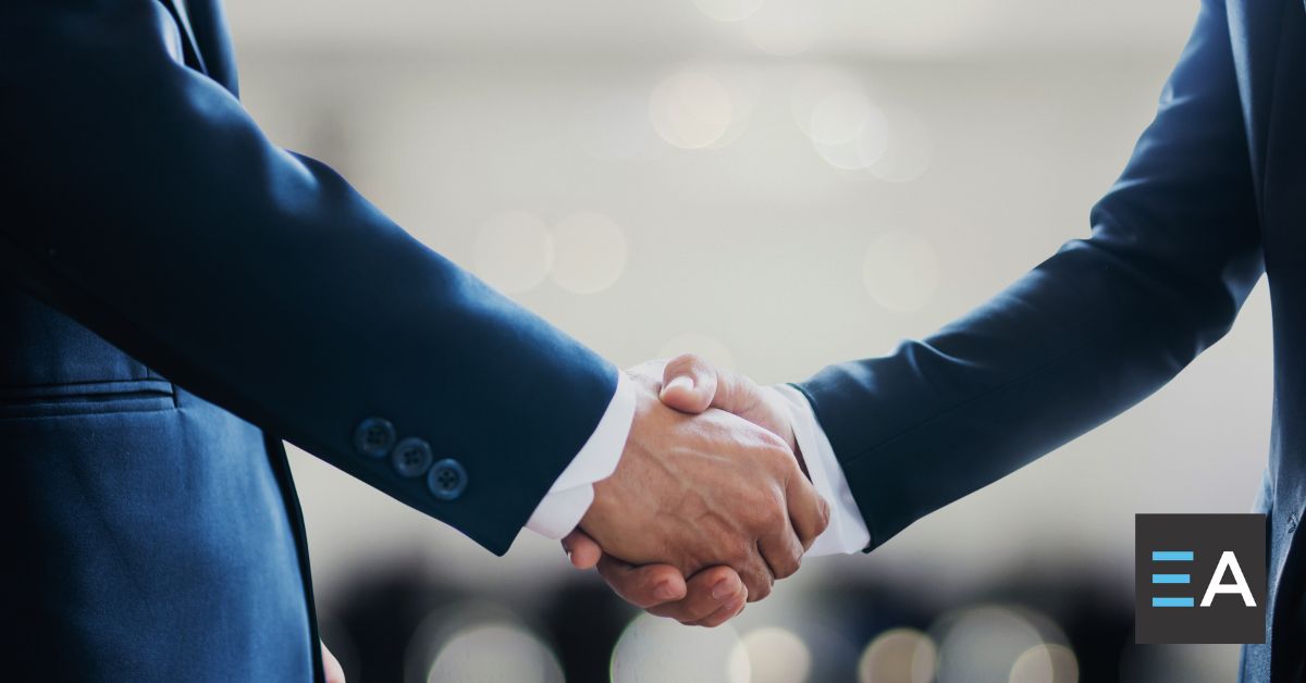 Two people in suits shaking hands