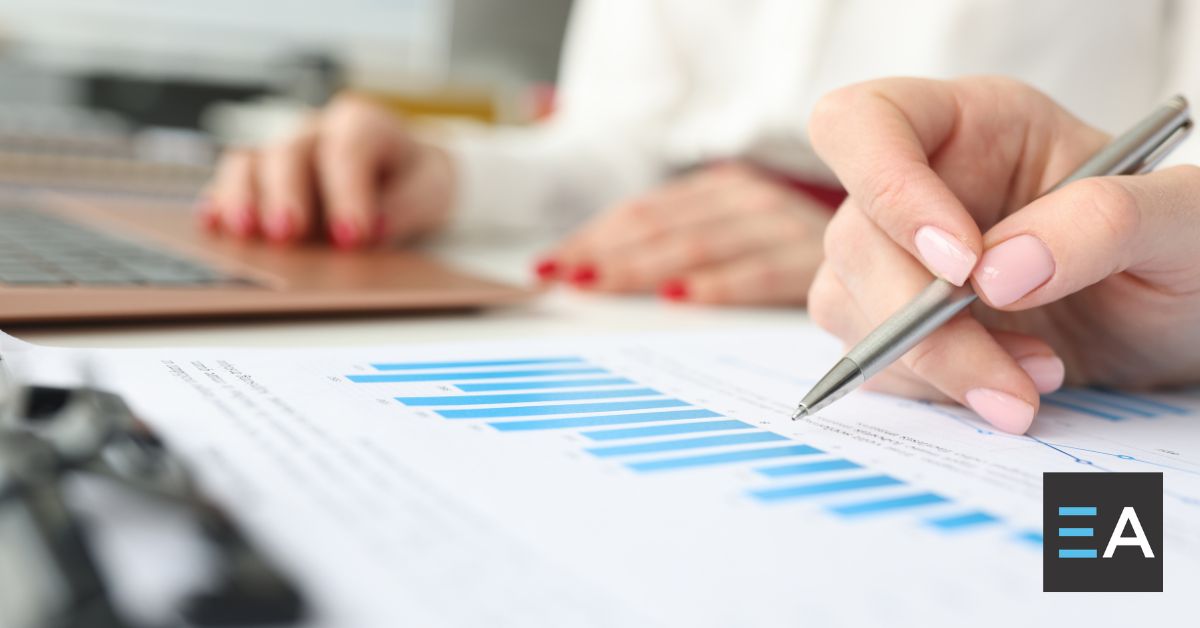 A person marking a print-out of a blue bar graph