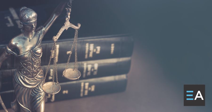 A statue of Lady Justice in front of three law books