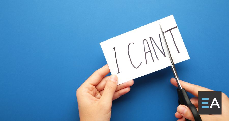 A card with the words "I can't" written on it; a person is using scissors to cut off the T