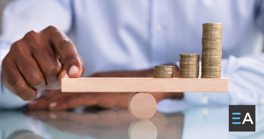 A person balancing a level with their finger on one end and stacks of coins on the other