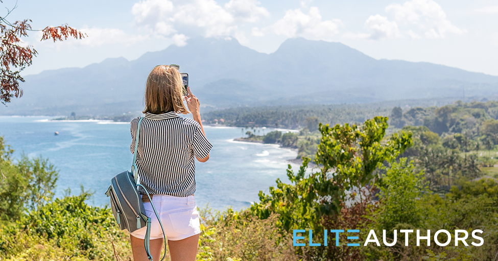 person taking a picture with their cell phone of a beautiful landscape