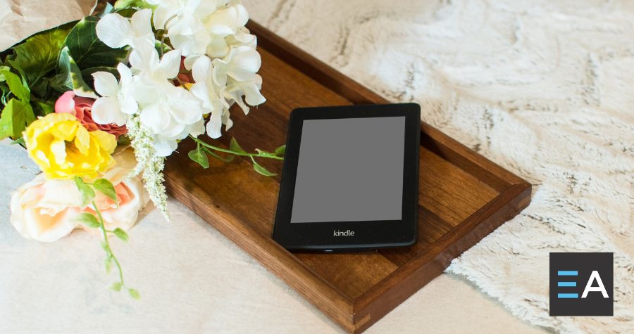 An e-reader lying on a tray next to flowers