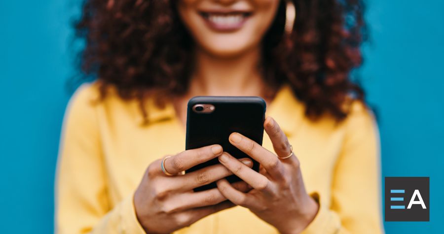 A person smiling at their smartphone