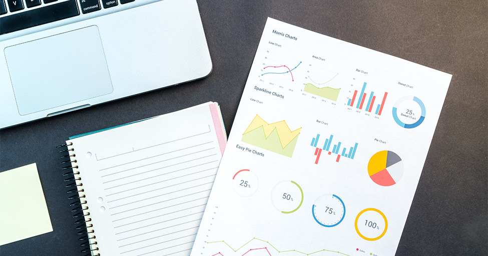 graphs and charts next to a laptop