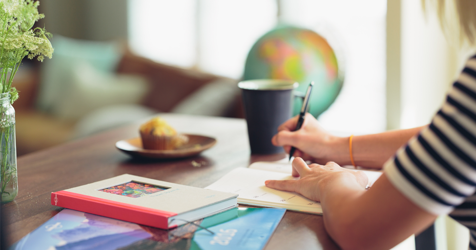 person writing in a calendar planner