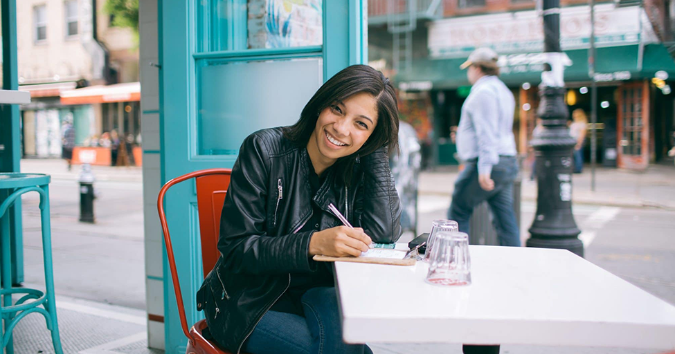 person at cafe with pen and paper