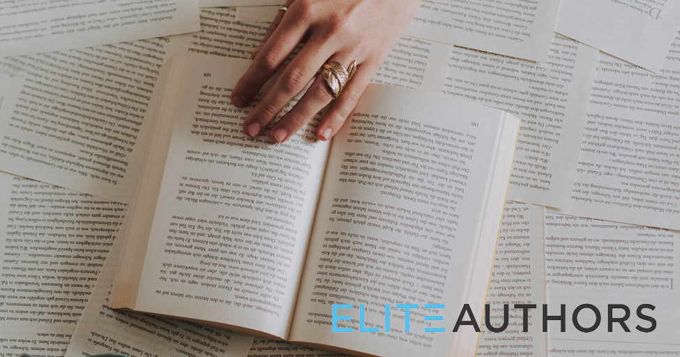 a hand holding a book on top of many loose book pages