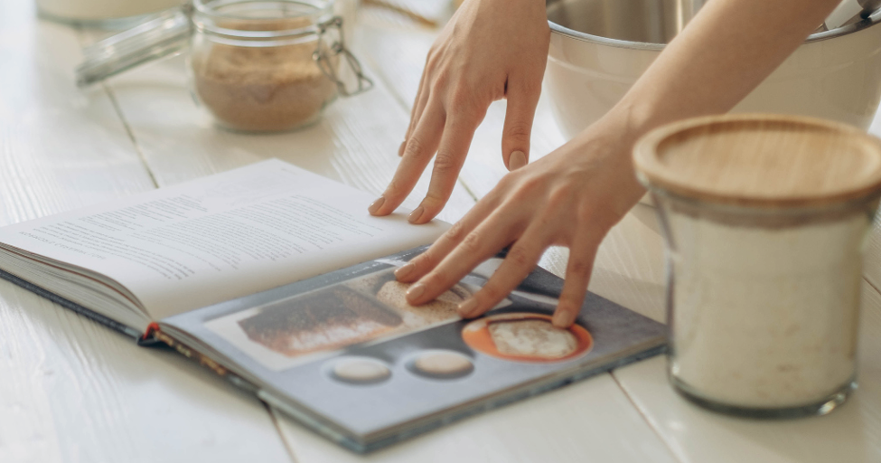 hands pushing down on a cook book