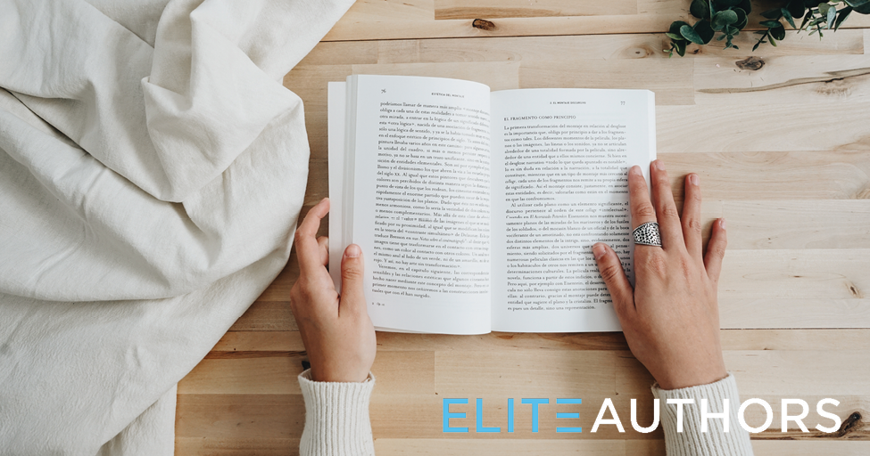 hands holding an open book on a table.