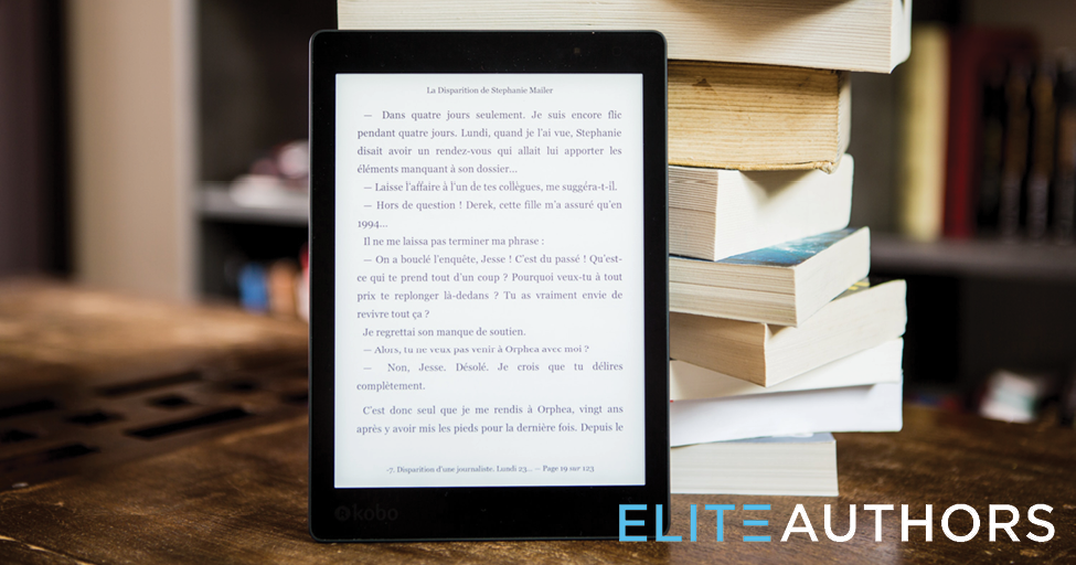 An Kindle displays an ebook next to a stack of print books