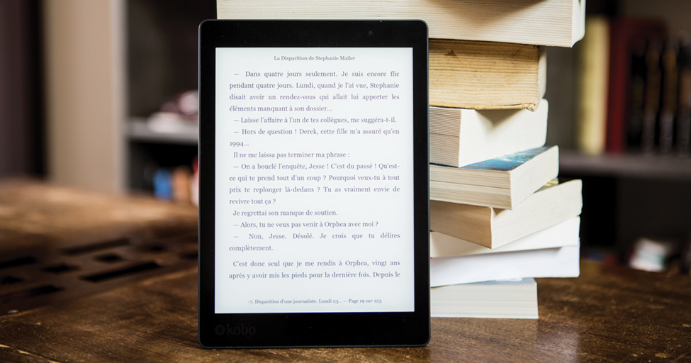 ebook in front of a stack of physical books